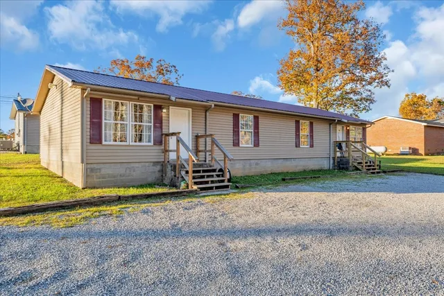 a view of backyard of house and car parked