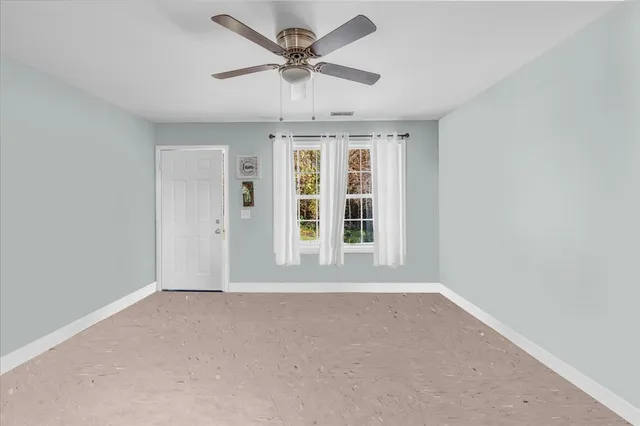 an empty room with a empty space and a ceiling fan