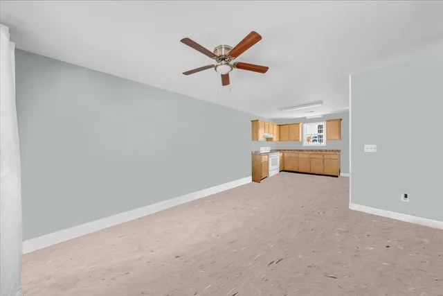a view of a livingroom with a ceiling fan and window