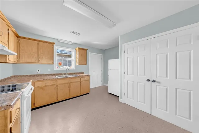 a kitchen with granite countertop white cabinets and white appliances