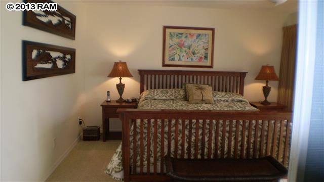 3833 Lower Honoapiilani Road, Unit A203 Lahaina, HI 96761 - Photo 11 of 26 a bedroom with a bed and a painting on the wall