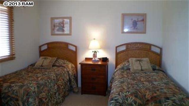 3833 Lower Honoapiilani Road, Unit A203 Lahaina, HI 96761 - Photo 12 of 26 a bedroom with a bed and a lamp on dresser