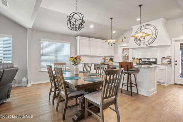a view of a dining room with furniture a chandelier and wooden floor