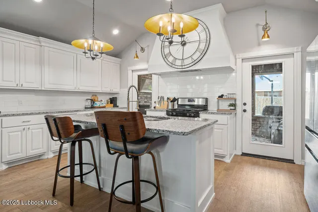 a kitchen with stainless steel appliances granite countertop a sink stove and cabinets