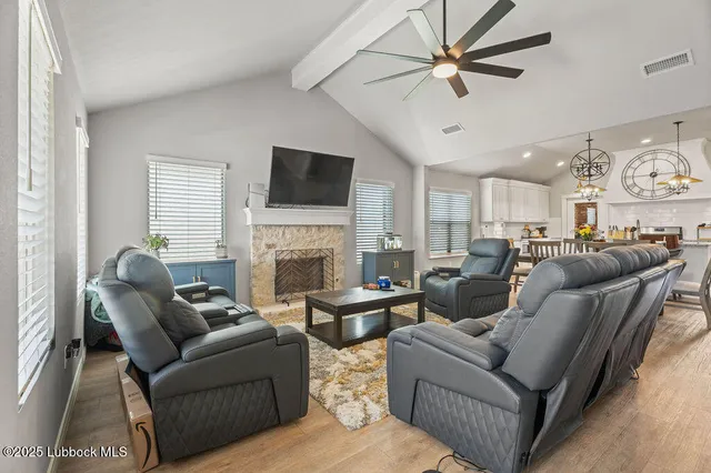 a living room with furniture a fireplace and a flat screen tv