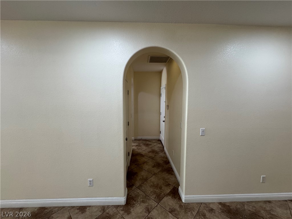 1333 Jamesbury Road Las Vegas, NV 89135 - Photo 10 of 43 An arched doorway provides an elegant transition between interior spaces, featuring classic tile flooring.