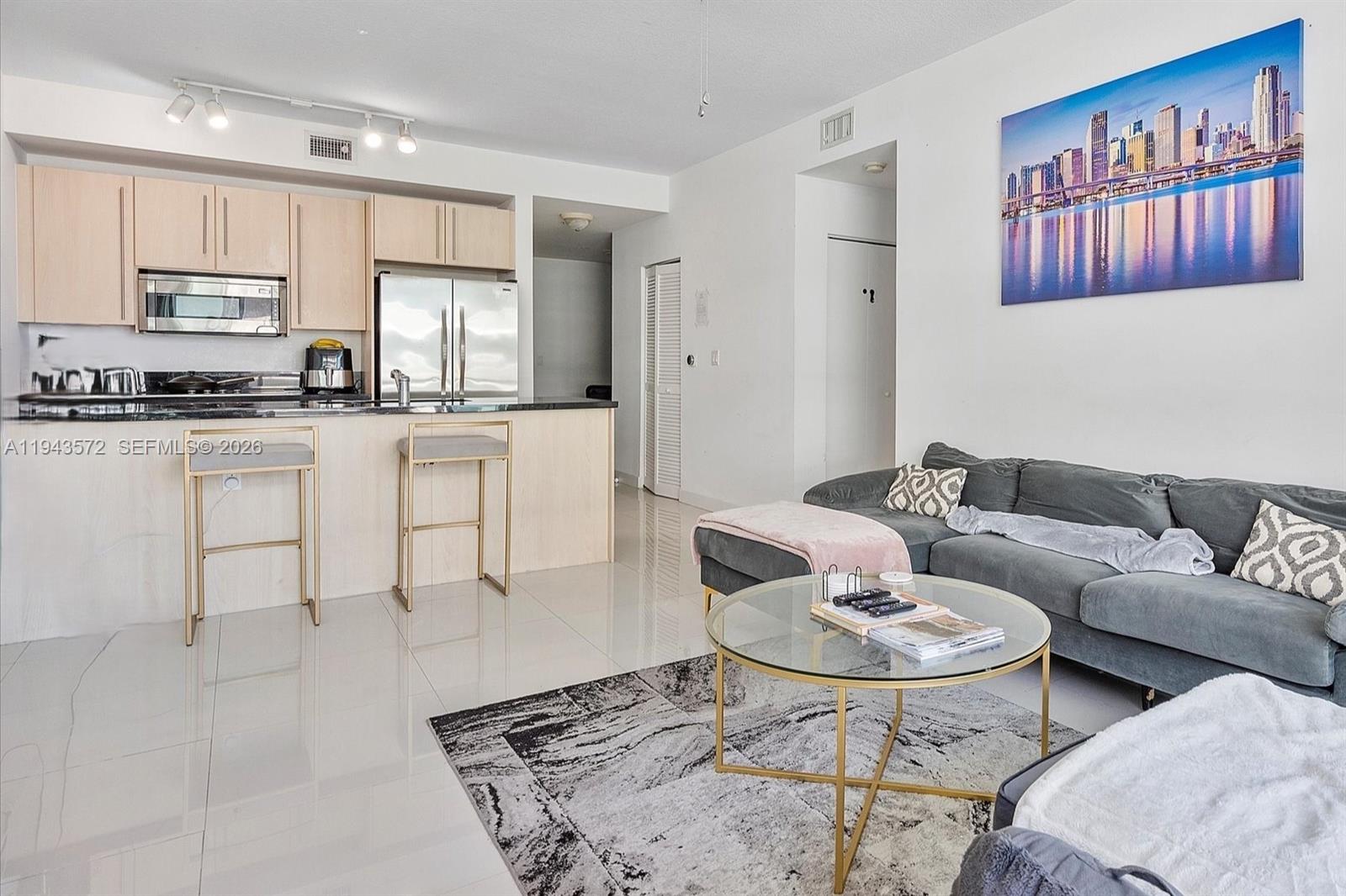 79 Southwest 12th Street, Unit 3809S Miami, FL 33130 - Photo 6 of 21 a living room with stainless steel appliances a table and chairs in it