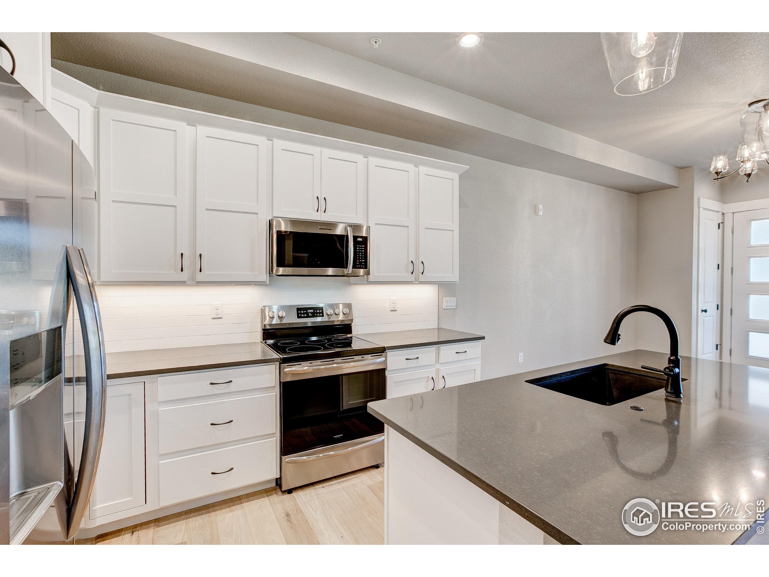 a kitchen with stainless steel appliances kitchen island a white counter top space and cabinets
