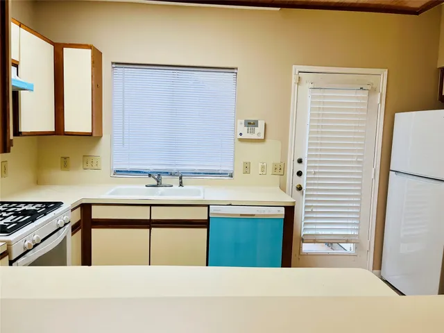 a kitchen with stainless steel appliances granite countertop a sink a stove and a refrigerator