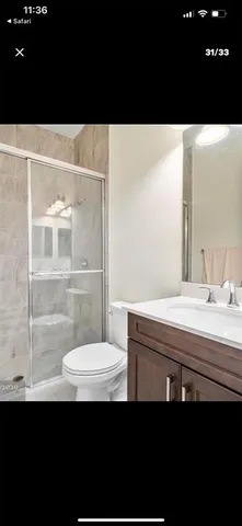 a bathroom with a sink a toilet a shower and a mirror