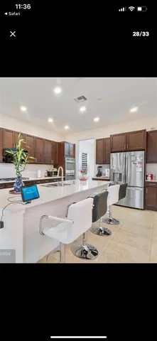 a open kitchen with kitchen island a sink dishwasher a stove and a refrigerator with wooden floor