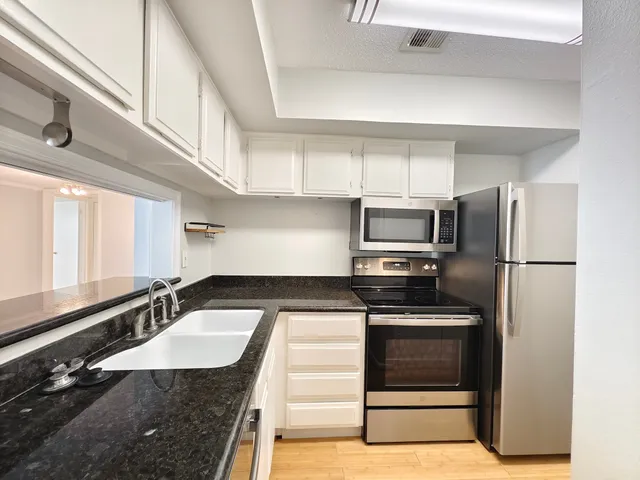 a kitchen with granite countertop a stove and a microwave