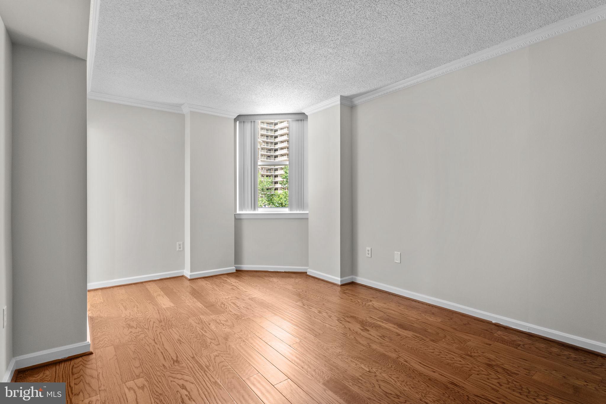 880 North Pollard Street, Unit 224 Arlington, VA 22203 - Photo 11 of 39 an empty room with wooden floor and windows
