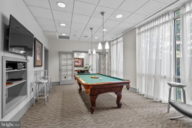 a room with pool table and windows