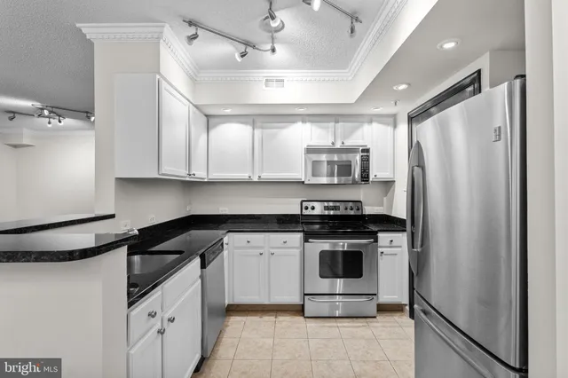 a kitchen with stainless steel appliances granite countertop a stove a refrigerator and a sink