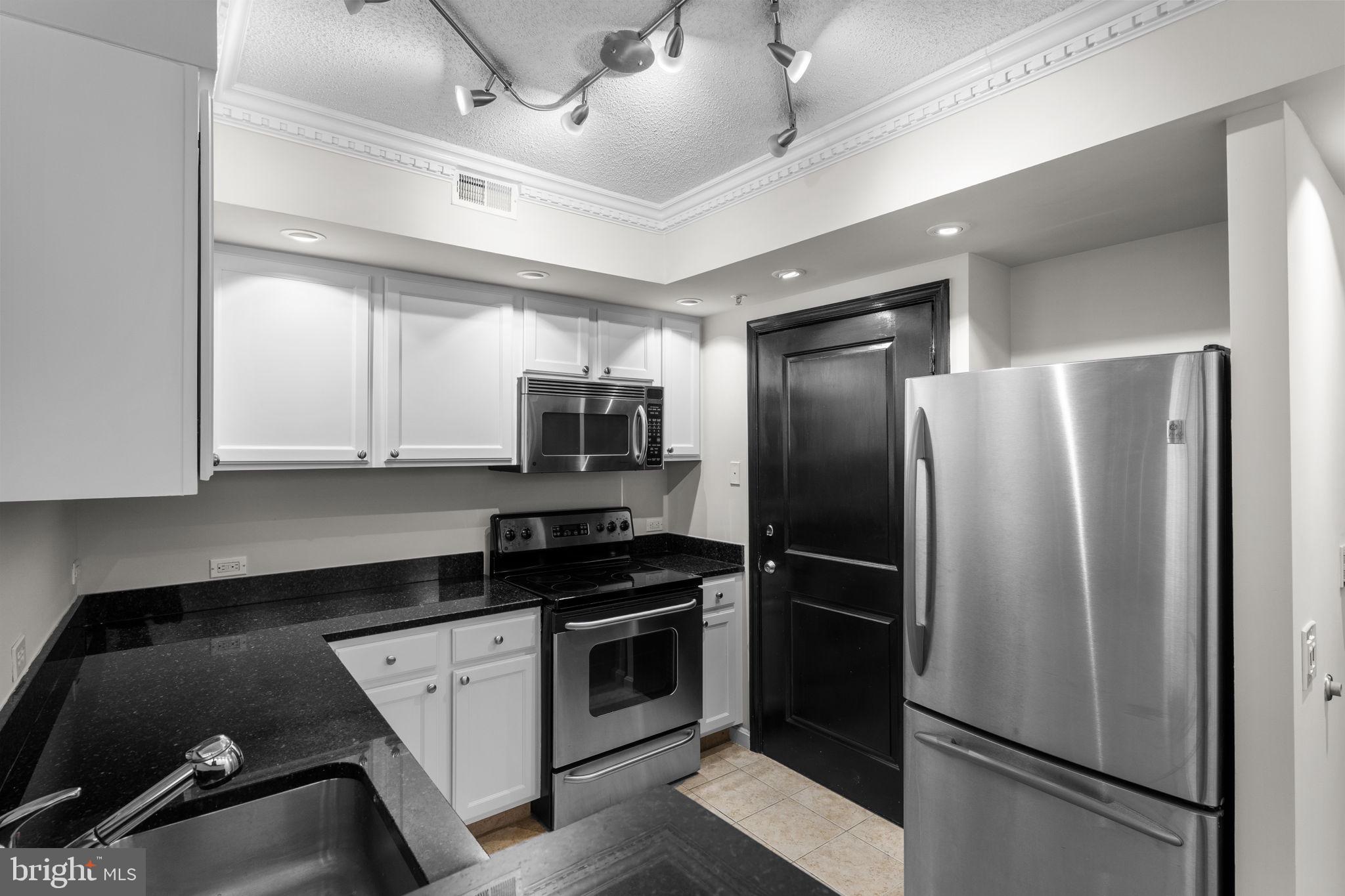 880 North Pollard Street, Unit 224 Arlington, VA 22203 - Photo 5 of 39 a kitchen with a refrigerator stove and cabinets