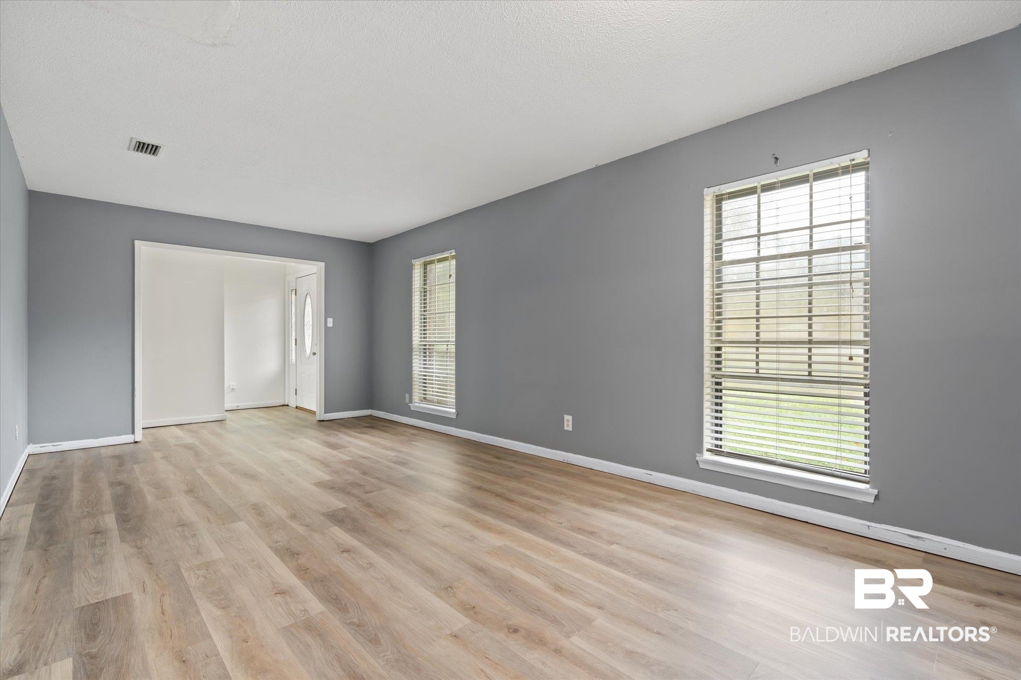 9445 Howells Ferry Road Semmes, AL 36575 - Photo 2 of 20 Empty room with light hardwood / wood-style floors and a healthy amount of sunlight