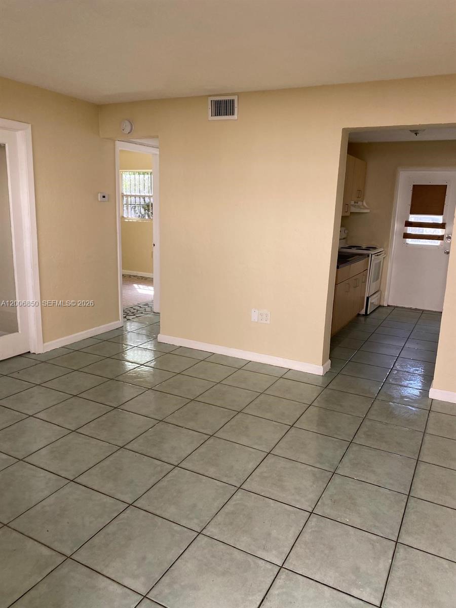 1319 Northwest 60th Street, Unit 5 Miami, FL 33142 - Photo 9 of 10 a view of a kitchen space with wooden floor and a window