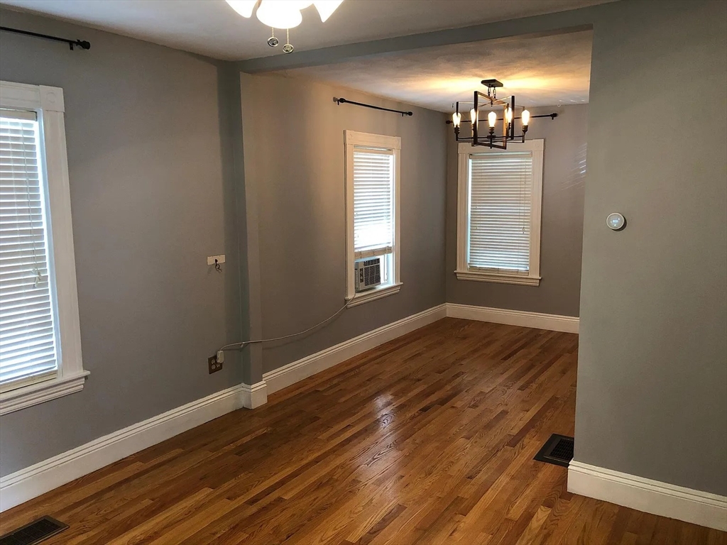 1 Webster Court Stoneham, MA 02180 - Photo 2 of 9 a view of an empty room with wooden floor and a window