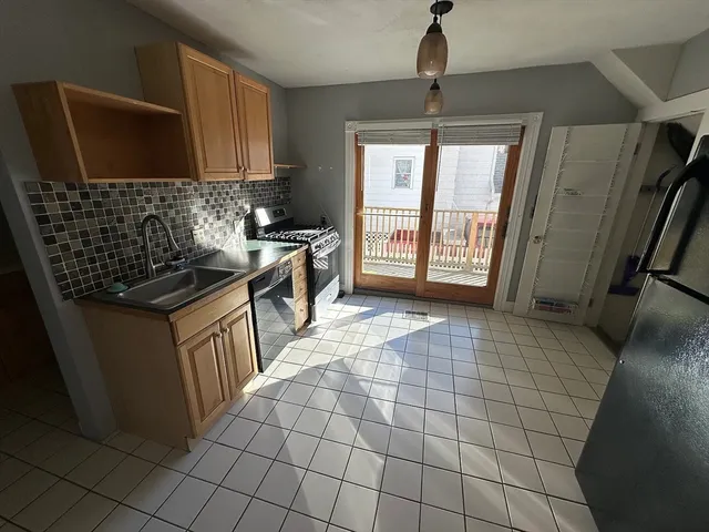 a kitchen with stainless steel appliances a sink stove and cabinets