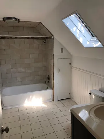 a bathroom with a granite countertop sink a toilet and bathtub
