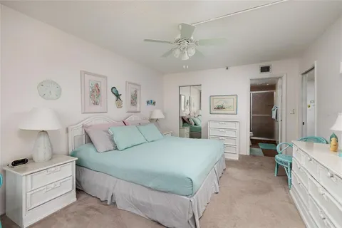 a spacious bedroom with a bed and a chandelier