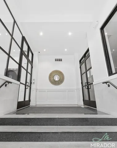 a view of staircase with white walls and a painting on the wall