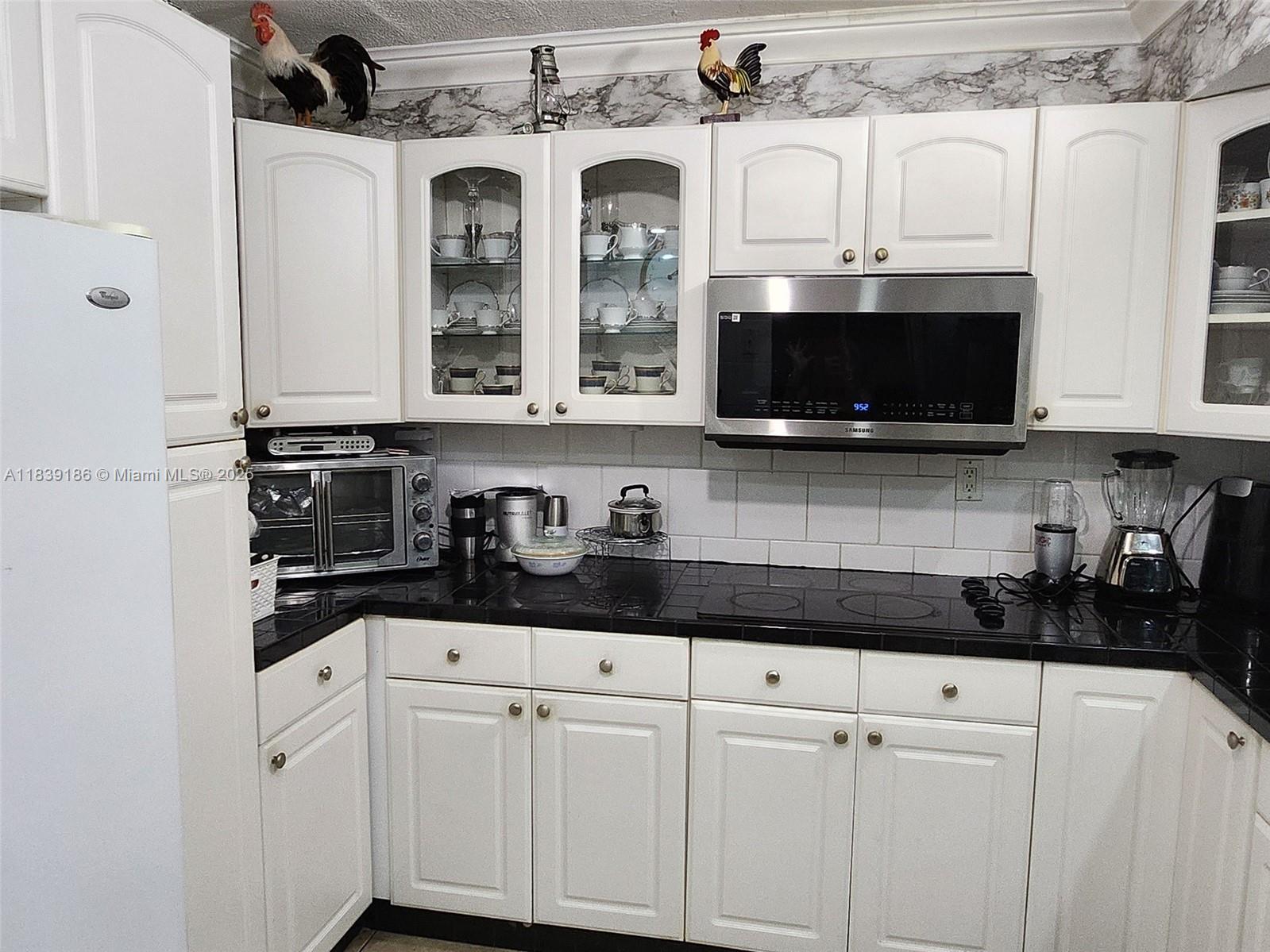 2750 Northeast 183rd Street, Unit 1701 Aventura, FL 33160 - Photo 11 of 40 a kitchen with stainless steel appliances granite countertop white cabinets and a stove a sink