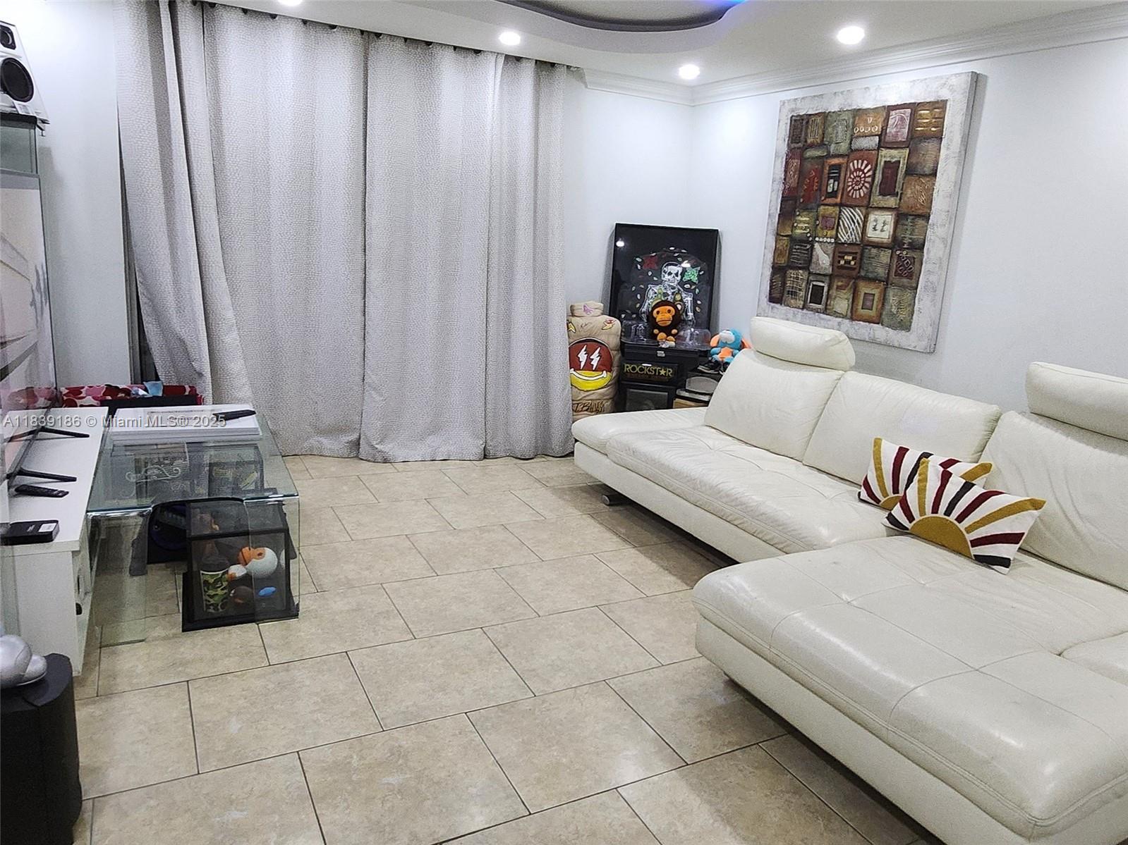 2750 Northeast 183rd Street, Unit 1701 Aventura, FL 33160 - Photo 3 of 40 a living room with furniture and a flat screen tv