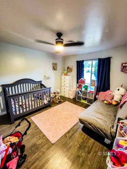 521 Sydnor Avenue Ridgecrest, CA 93555 - Photo 15 of 28 a bedroom with furniture and a wooden floor