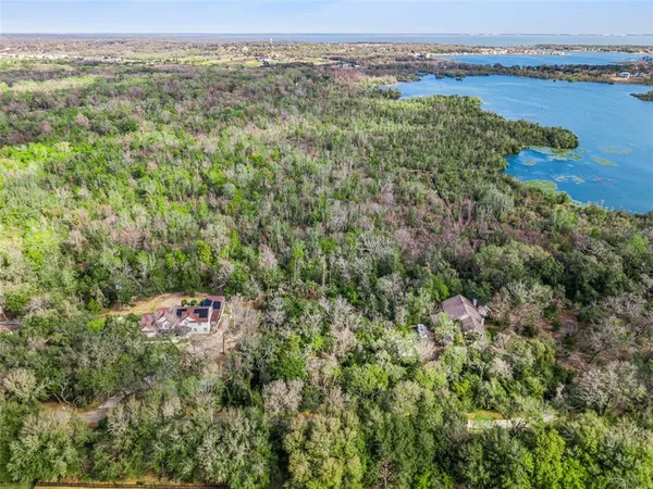 an aerial view of a house with a garden and lake view