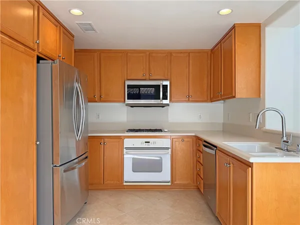 a kitchen with stainless steel appliances granite countertop a refrigerator stove top oven a sink and dishwasher