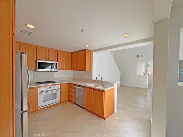 a kitchen with stainless steel appliances granite countertop a stove a sink and a refrigerator