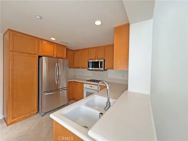 a kitchen with stainless steel appliances granite countertop a refrigerator a stove a sink and a microwave