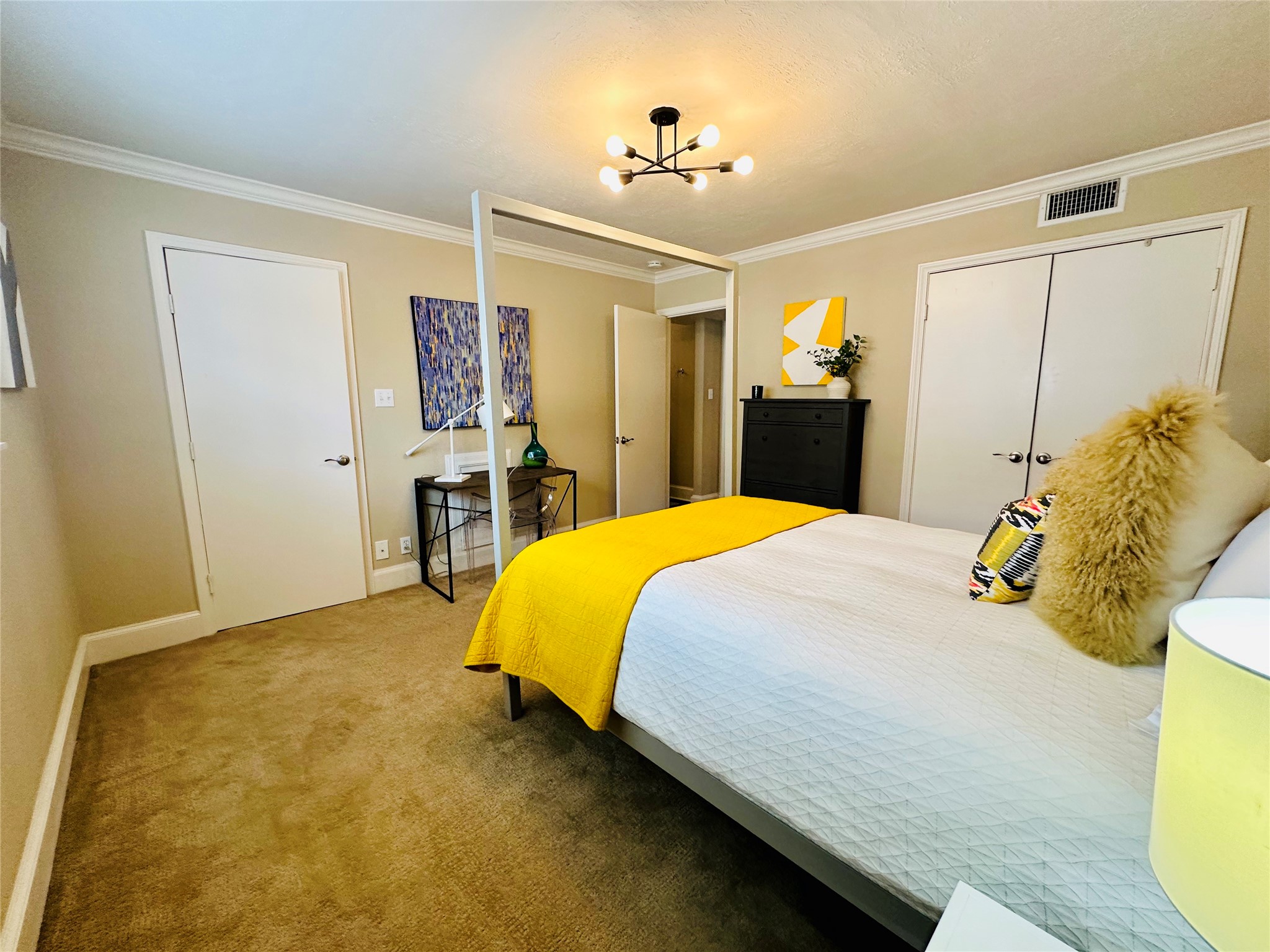 3402 Garrott Street, Unit 16 Houston, TX 77006 - Photo 18 of 47 a bedroom with a bed and a chandelier