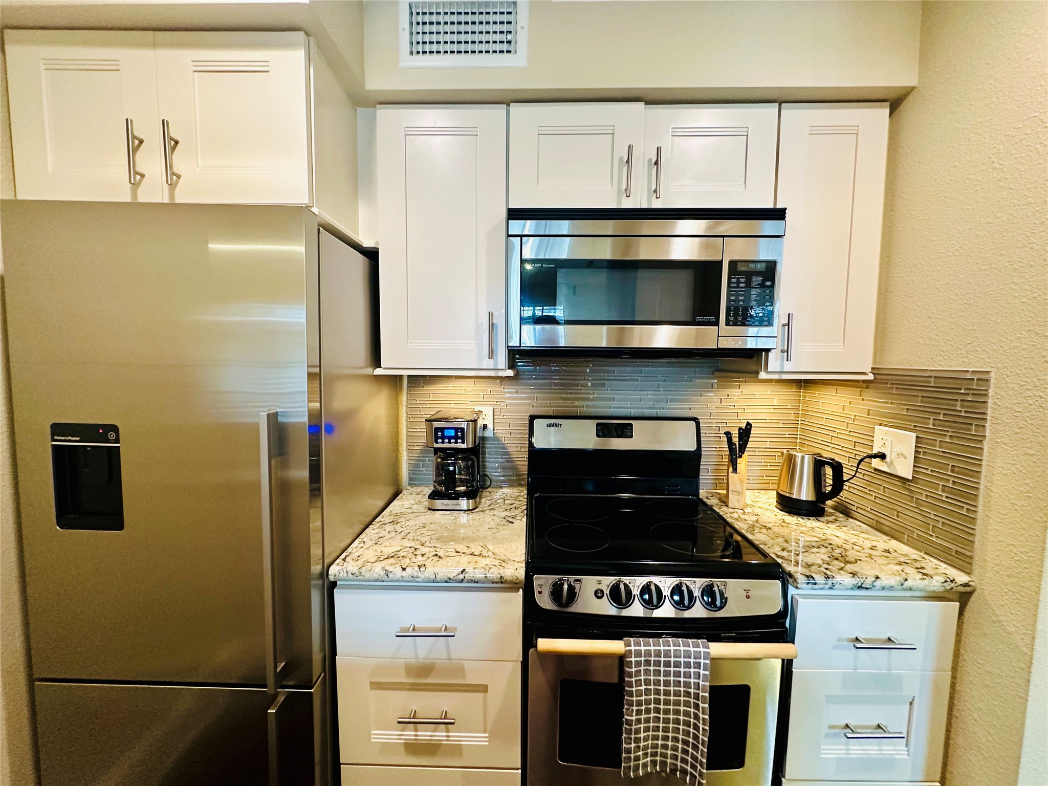 3402 Garrott Street, Unit 16 Houston, TX 77006 - Photo 29 of 47 a kitchen with granite countertop cabinets stove and microwave