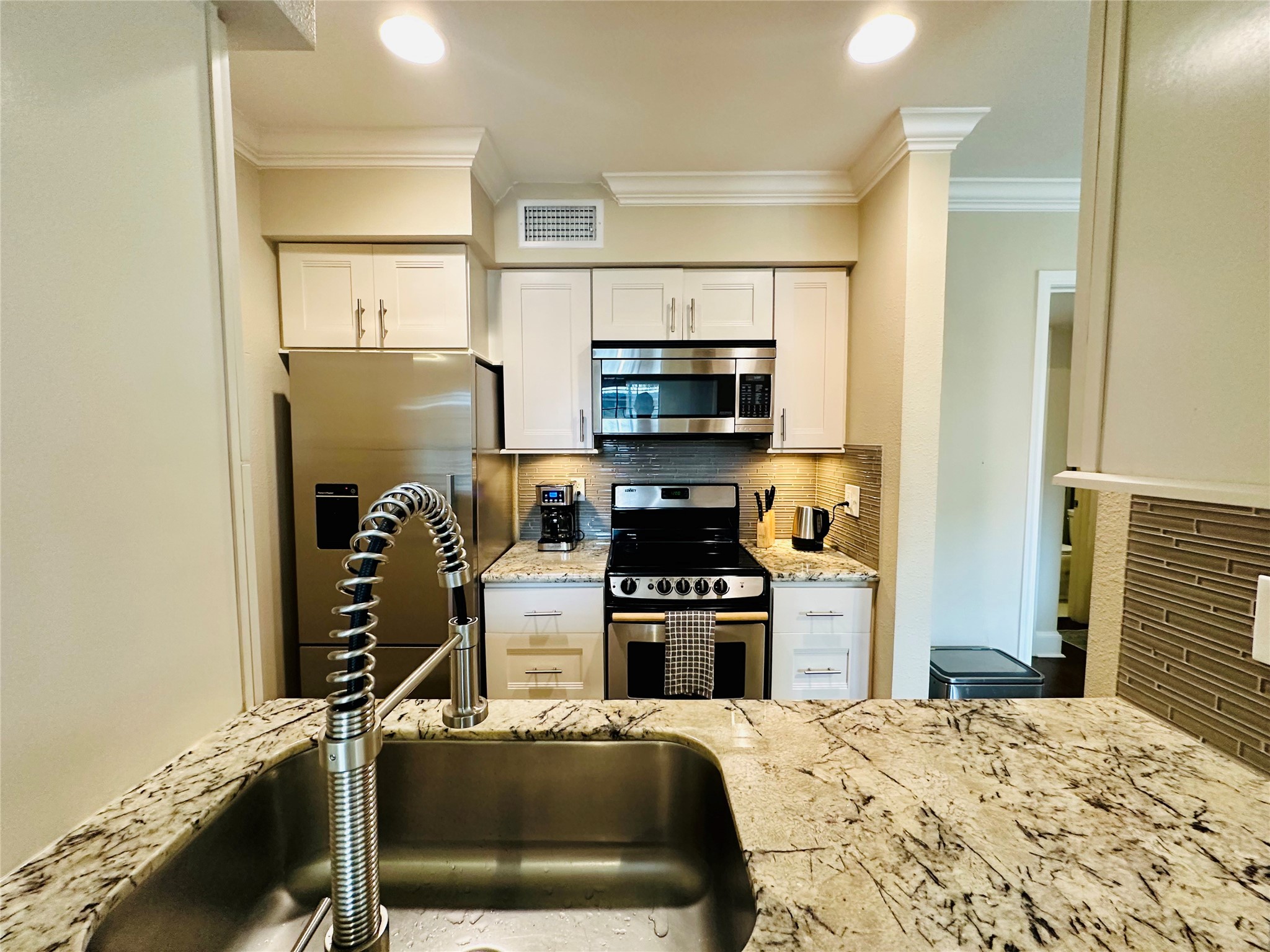 3402 Garrott Street, Unit 16 Houston, TX 77006 - Photo 3 of 47 a kitchen with kitchen island a counter top space appliances and a view of living room
