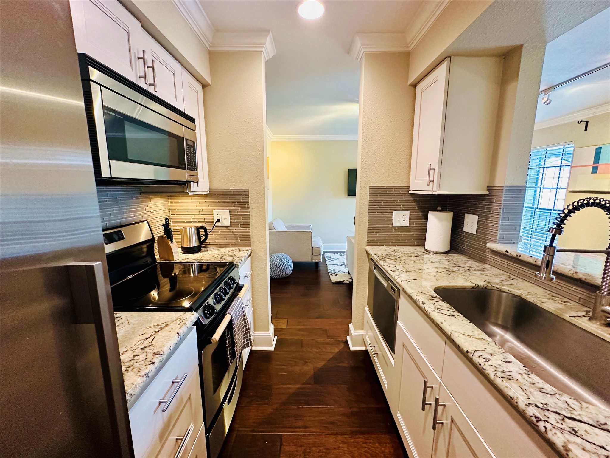 3402 Garrott Street, Unit 16 Houston, TX 77006 - Photo 4 of 47 a kitchen with stainless steel appliances granite countertop a stove a sink and a microwave