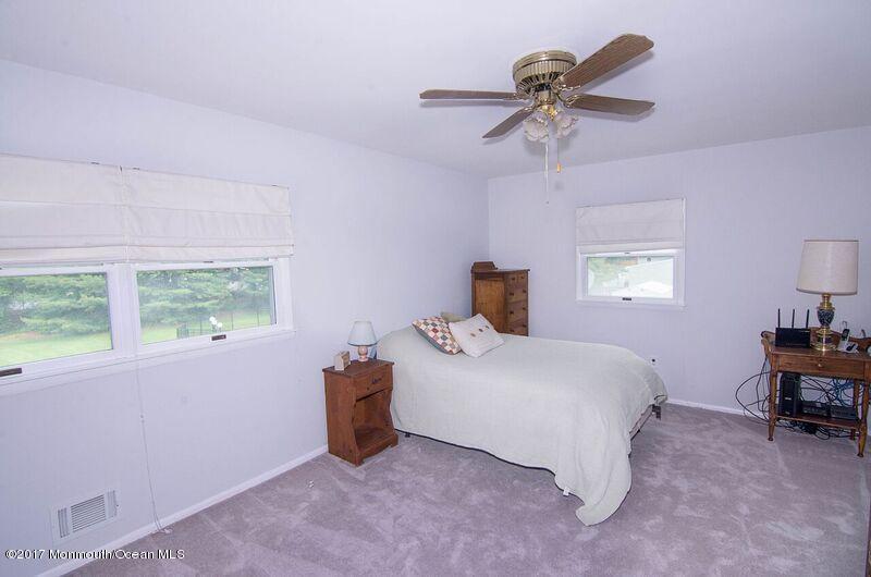 800 Waterworks Road Freehold, NJ 07728 - Photo 19 of 28 a bedroom with a bed and a chandelier