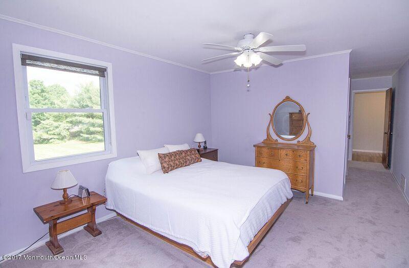 800 Waterworks Road Freehold, NJ 07728 - Photo 20 of 28 a bedroom with a bed and a chandelier