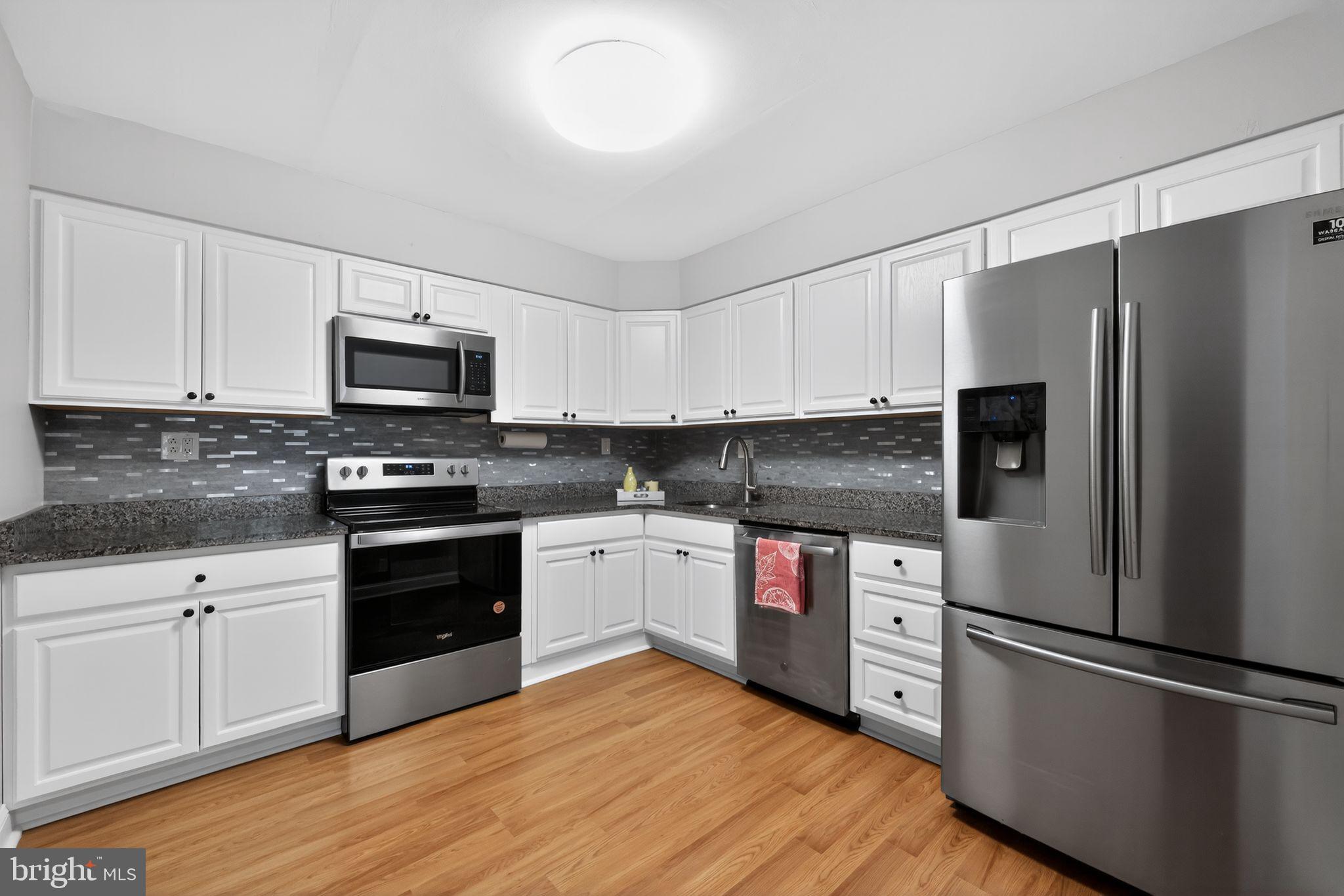 400 Glendale Road, Unit F35 Havertown, PA 19083 - Photo 16 of 36 a kitchen with granite countertop a refrigerator stove and microwave