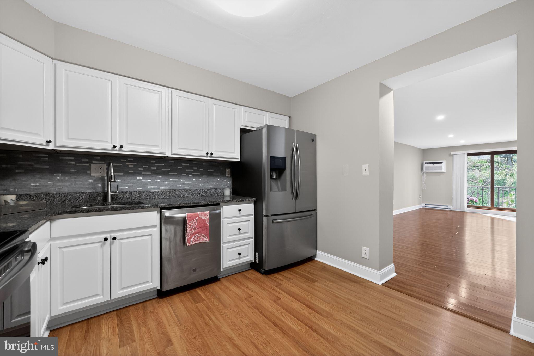 400 Glendale Road, Unit F35 Havertown, PA 19083 - Photo 17 of 36 a kitchen with stainless steel appliances granite countertop a refrigerator oven a stove with white cabinets and wooden floor