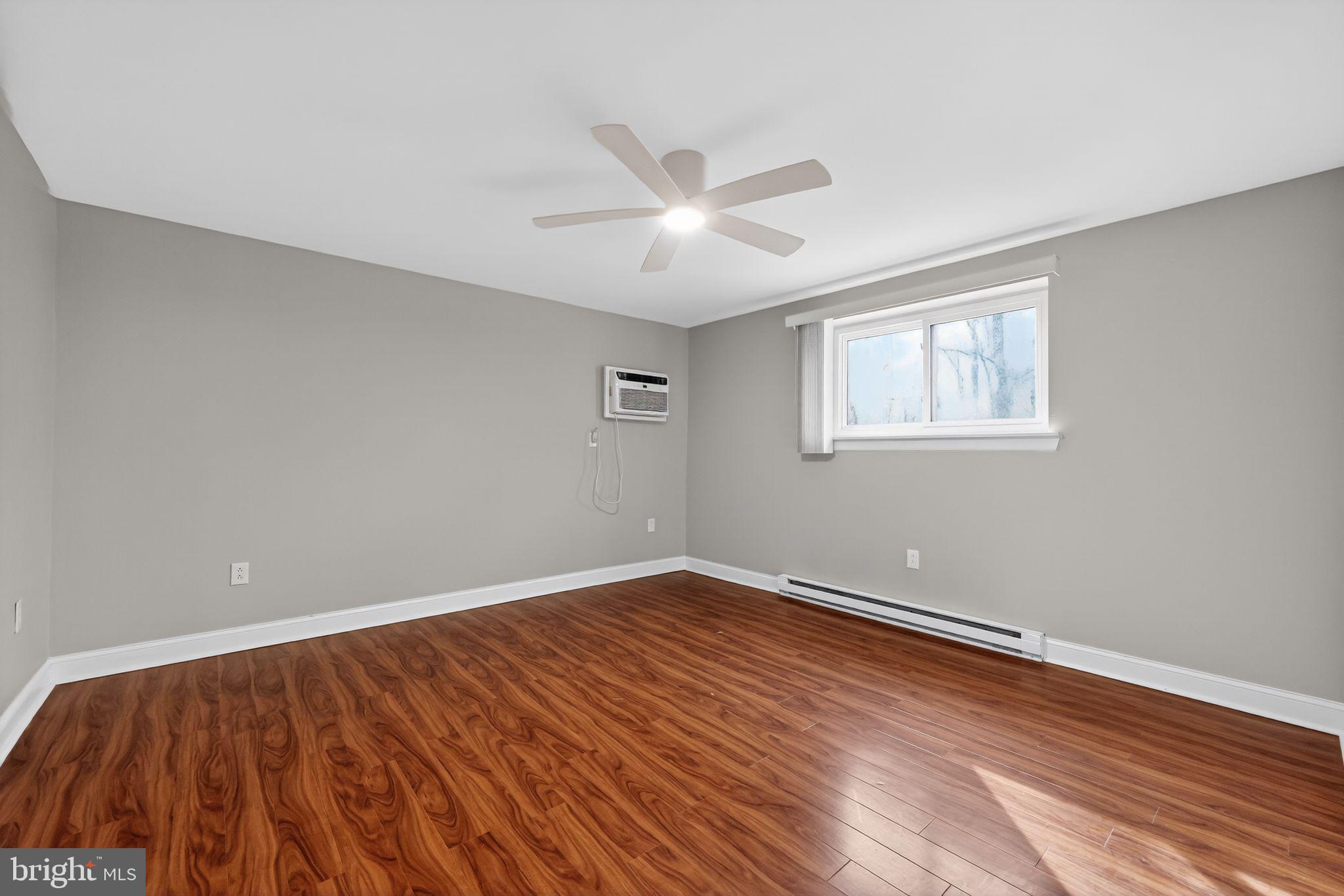 400 Glendale Road, Unit F35 Havertown, PA 19083 - Photo 22 of 36 an empty room with wooden floor ceiling fan and windows