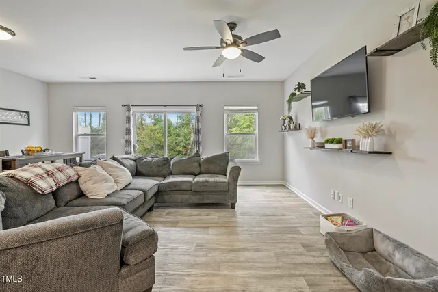 a living room with furniture a flat screen tv and white walls