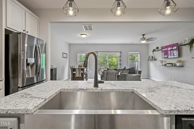 a view with kitchen island a sink a refrigerator and living room view