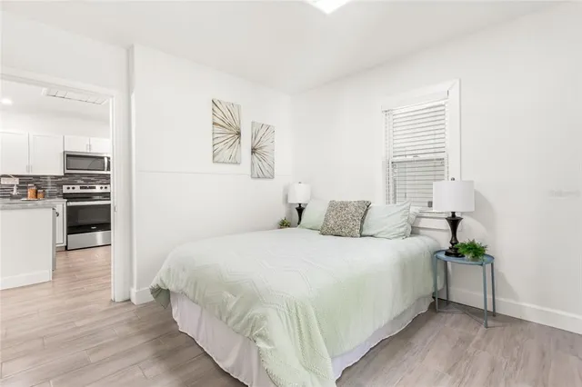a bedroom with a bed and wooden floor