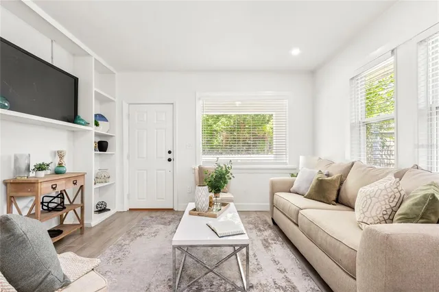 a living room with furniture a flat screen tv and a large window