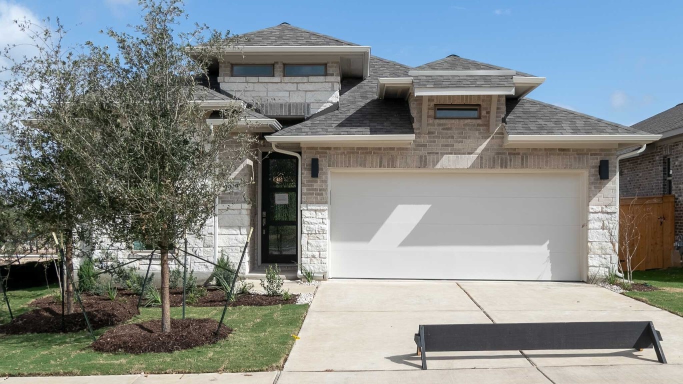 a front view of a house with a garden