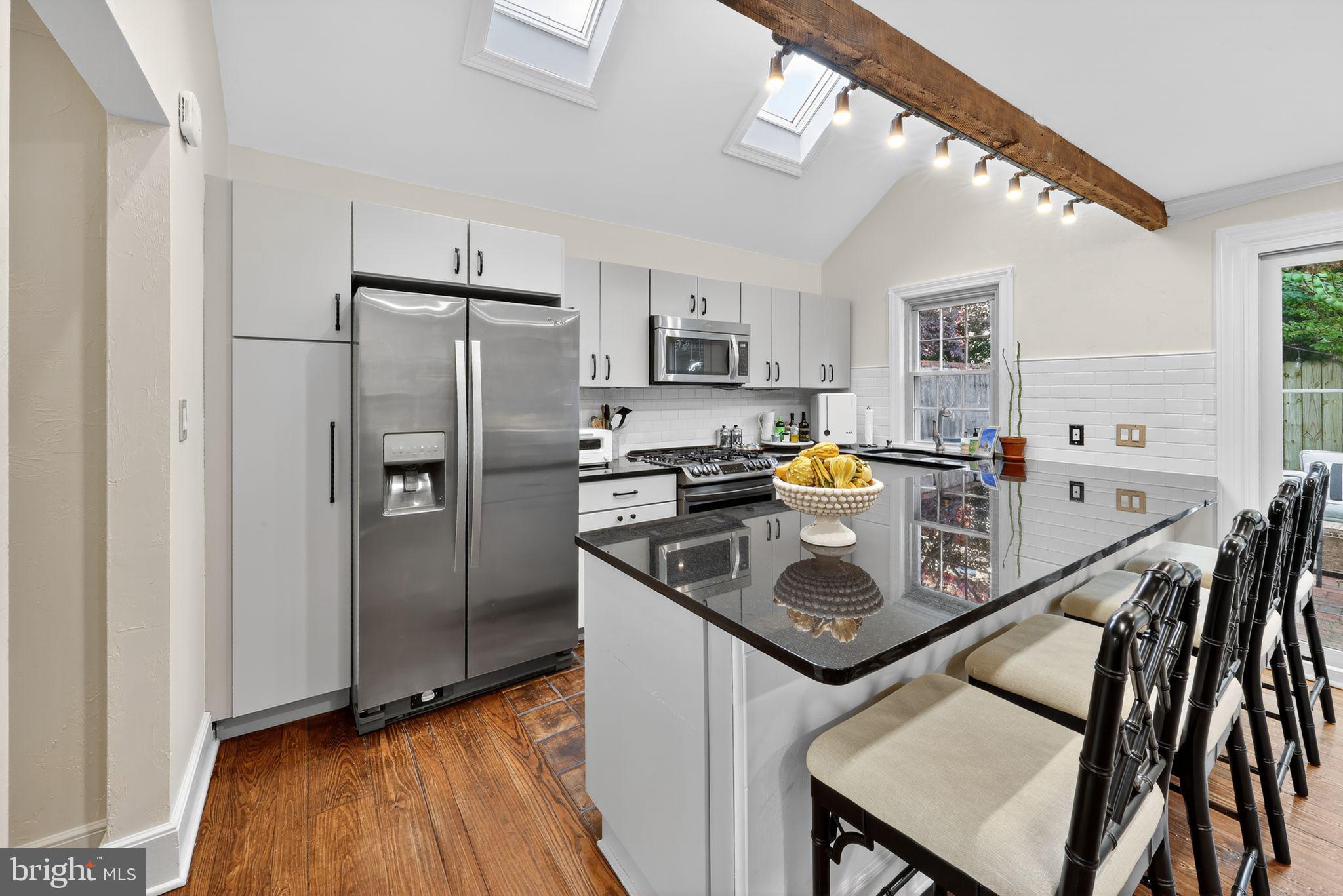 10 Rockford Road Wilmington, DE 19806 - Photo 14 of 30 a kitchen with stainless steel appliances granite countertop a refrigerator a stove top oven a sink dishwasher and a refrigerator with wooden floor