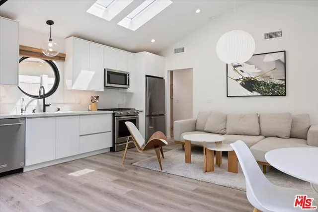 a living room with furniture a mirror and a dining table with wooden floor